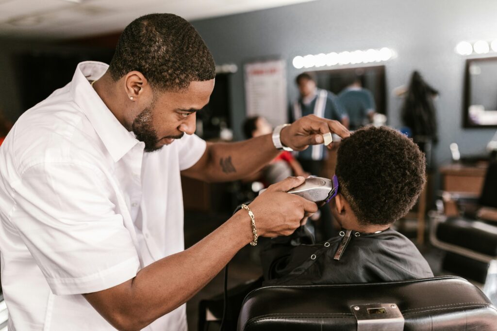 Professional barber giving a precise haircut to a client in a stylish barbershop setting.